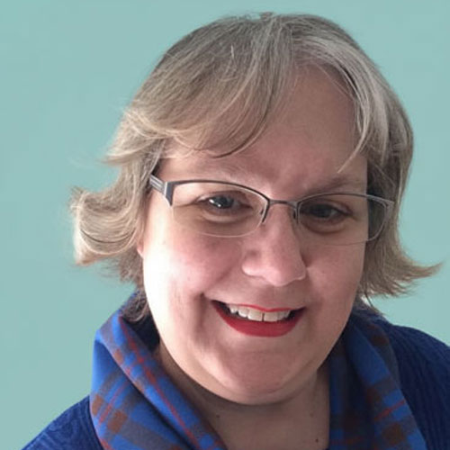 A photo of Holly Nelson in her Elliot clan tartan and a bright blue sweater.